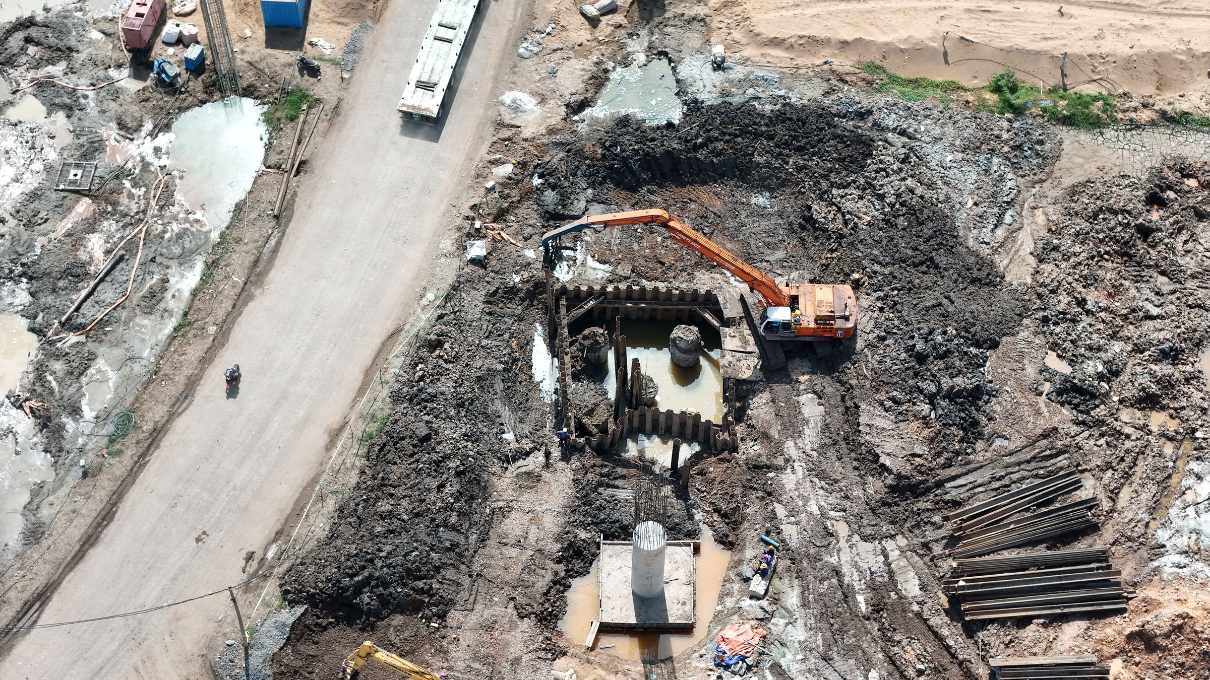 Aerial view of a deep excavation with machinery and stacked materials